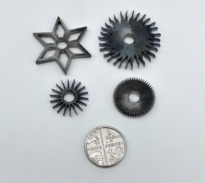 Small intricate laser cut parts, showing detailed parts cut from various metals.