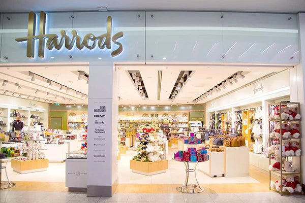 Shop store front with metal harrods logo on display.