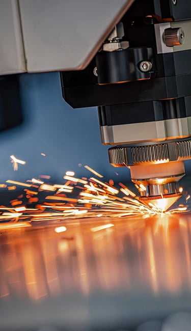 Flat Sheet Metal laser cutting process with sparks in a manufacturing setting