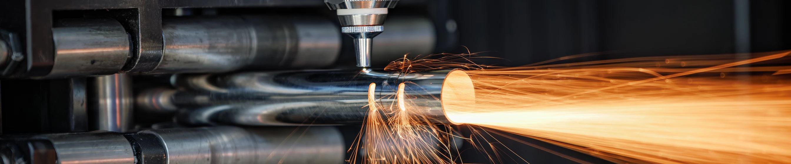 Tube CNC machine cutting metal with sparks flying