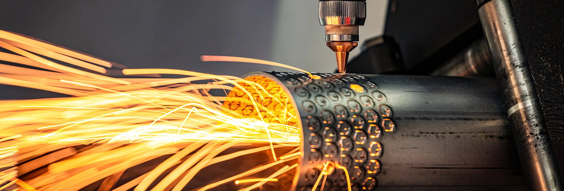 Tube laser machine cutting round mild steel with sparks flying out
