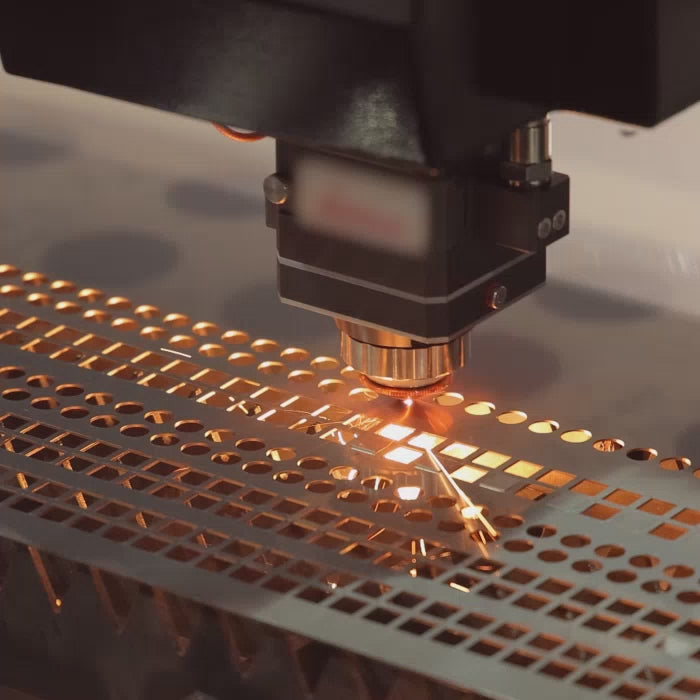 Flat Laser cutting perforating holes into metal sheet with sparks flying