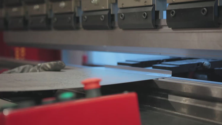 Press braking machine being operated and folding a metal sheet