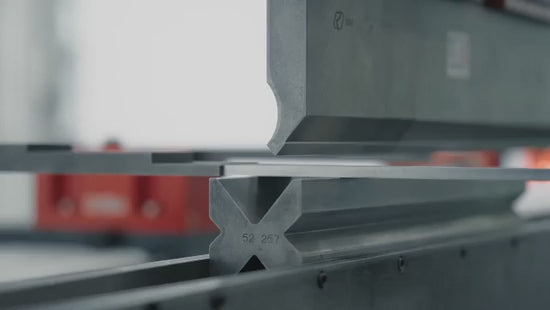 Automated press brake machine folding flat sheet metal in industrial metal fabrication factory